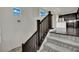 Staircase featuring carpeted steps, wooden railing, and elegant chandelier, with a glimpse into the kitchen at 1185 Via Dimartini, Henderson, NV 89052