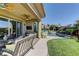 Inviting backyard featuring a pool, lawn, and outdoor seating with ceiling fan at 12318 Tudor Arch Dr, Las Vegas, NV 89138