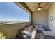 Outdoor balcony with comfortable seating, fan, and views of city landscape with mountains in the background at 12318 Tudor Arch Dr, Las Vegas, NV 89138