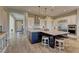 An open kitchen with an oversized island with seating, stainless steel appliances, and stylish pendant lighting at 12318 Tudor Arch Dr, Las Vegas, NV 89138
