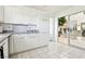 Bright kitchen with white cabinets, stainless dishwasher, and a pass-through to a garden room at 1409 Pueblo Dr, Boulder City, NV 89005