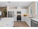 Stylish kitchen with white cabinets, stainless steel appliances, modern countertops, and wood-look flooring throughout at 145 Harmonica Ave # Lot 23, Henderson, NV 89015