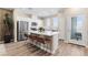 Modern kitchen features an island with bar stool seating, white cabinets, stainless steel appliances and wood-look flooring at 145 Harmonica Ave # Lot 23, Henderson, NV 89015