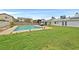 Wide backyard with a pool, green grass, and perimeter fencing, perfect for outdoor enjoyment at 1595 E Camero Ave, Las Vegas, NV 89123