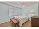 Bedroom featuring a bed, wooden floors, bench, ceiling fan, and large window at 1595 E Camero Ave, Las Vegas, NV 89123