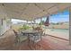 Covered outdoor patio with an umbrella, seating and string lights overlooking the backyard pool at 1595 E Camero Ave, Las Vegas, NV 89123