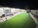 Covered backyard patio with lush artificial grass, ideal for outdoor living and activities at 1619 Tangerine Rose Dr, Las Vegas, NV 89142