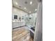 Bathroom featuring double sinks, white cabinetry, a luxurious marble shower, and wood-look floors at 1619 Tangerine Rose Dr, Las Vegas, NV 89142