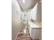 Hallway with white cabinets, recessed lights, wood floors, and access to multiple rooms at 1619 Tangerine Rose Dr, Las Vegas, NV 89142