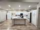 Bright kitchen boasting a center island, modern white cabinetry, stainless steel appliances, and wood floors at 1619 Tangerine Rose Dr, Las Vegas, NV 89142