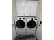 Modern laundry room with white cabinets, and front loading washer and dryer at 1619 Tangerine Rose Dr, Las Vegas, NV 89142