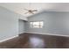 Large bedroom with dark hardwood floors, fan and bright natural light from windows at 1924 Coralino Dr, Henderson, NV 89074