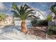 Angle view showing a three-car garage, tile roof, desert landscaping, and white stucco exterior at 1924 Coralino Dr, Henderson, NV 89074