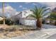 Two-story home with a three-car garage, tile roof, and desert landscaping under a partly cloudy sky at 1924 Coralino Dr, Henderson, NV 89074