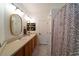 Neutral bathroom featuring a double vanity, unique mirrors, and a patterned shower curtain at 2021 Pelican Sky Beach Ave, North Las Vegas, NV 89081