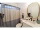 Modern bathroom featuring stylish mirror, sleek sink, and neutral-toned shower curtain at 2021 Pelican Sky Beach Ave, North Las Vegas, NV 89081