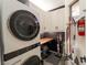 Functional laundry room with modern washer/dryer, ample storage, and organized cleaning supplies at 2021 Pelican Sky Beach Ave, North Las Vegas, NV 89081