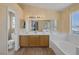 Bright primary bathroom featuring double sinks, ample counter space, a separate shower, and a luxurious soaking tub under a window at 2147 Bridle Wreath Ln, Las Vegas, NV 89156