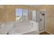 Bright bathroom with a garden tub, a separate glass shower, a large window, and decorative walls at 2147 Bridle Wreath Ln, Las Vegas, NV 89156