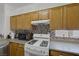 Well-lit kitchen featuring tile backsplash, light wood cabinets and a white gas range at 2147 Bridle Wreath Ln, Las Vegas, NV 89156