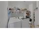 Bright laundry room featuring modern washer and dryer with ample shelving at 2147 Bridle Wreath Ln, Las Vegas, NV 89156