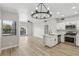 Open-concept living room boasts a modern chandelier, light wood floors, and a stainless steel kitchen at 2201 Ramsgate Dr # 327, Henderson, NV 89074