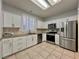Modern kitchen featuring stainless steel appliances, white cabinets, and stylish tile flooring at 2343 Scotch Lake St, Las Vegas, NV 89134