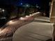 Charming backyard featuring landscape lighting highlighting the decorative rock and walkway for evening ambiance at 2804 Sapphire Desert Dr, Henderson, NV 89052