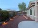 Charming backyard featuring garden bed lighting, gravel landscaping, and a concrete patio with a tree at 2804 Sapphire Desert Dr, Henderson, NV 89052