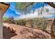 The backyard offers a combination of decorative rock, mature trees, and landscaping for privacy and natural beauty at 2804 Sapphire Desert Dr, Henderson, NV 89052