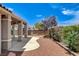 Charming backyard with covered patio, mature landscaping, and paved walkway at 2804 Sapphire Desert Dr, Henderson, NV 89052