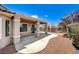 Charming backyard with covered patio, mature landscaping, and paved walkway at 2804 Sapphire Desert Dr, Henderson, NV 89052