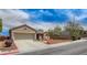 Tan single-story home with desert landscaping, a two-car garage, and a wide driveway at 2804 Sapphire Desert Dr, Henderson, NV 89052