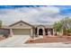 Tan single-story home with desert landscaping, a two-car garage, and a charming entrance at 2804 Sapphire Desert Dr, Henderson, NV 89052