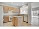 Kitchen with oak cabinets, tile floors, island, and view to the living room at 2804 Sapphire Desert Dr, Henderson, NV 89052
