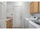 Well-lit laundry room featuring a side-by-side washer and dryer, and ample cabinet space at 2804 Sapphire Desert Dr, Henderson, NV 89052