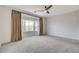 Spacious main bedroom with plush carpeting, ceiling fan, and large windows with stylish curtains at 2804 Sapphire Desert Dr, Henderson, NV 89052