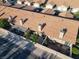 Aerial view of the property featuring a private patio, lush landscaping, and a traditional clay tile roof at 305 Crosswind Way, Las Vegas, NV 89145