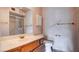 Bathroom featuring a vanity, mirror, cabinet, toilet and a shower with glass doors at 305 Crosswind Way, Las Vegas, NV 89145