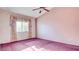 Spacious bedroom featuring a ceiling fan, and a large window with floral curtains at 305 Crosswind Way, Las Vegas, NV 89145