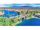 Breathtaking aerial shot of a neighborhood with a lake, bridge, lush greenery, and mountains in the distance at 3109 Siena Cir, Las Vegas, NV 89128