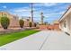Backyard featuring artificial turf and a cozy red seating area, enclosed with a block wall for privacy at 3109 Siena Cir, Las Vegas, NV 89128