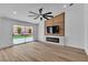 Living room featuring a ceiling fan, fireplace, tv, and sliding glass door to the backyard at 3109 Siena Cir, Las Vegas, NV 89128