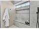 This shower has tile walls, a bench, shelves, and a black shower head with a glass door at 3109 Siena Cir, Las Vegas, NV 89128