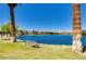 Picturesque view of a lake with palm trees and a cozy bench at 3109 Siena Cir, Las Vegas, NV 89128