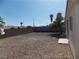 Large backyard with desert landscaping, mature tree, perimeter wall and small patio at 319 Mulberry Glen Dr, North Las Vegas, NV 89031