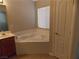 Cozy bathroom featuring a corner tub, warm wood cabinets, and natural light at 319 Mulberry Glen Dr, North Las Vegas, NV 89031