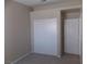 Bedroom with neutral carpet, closet with sliding doors, and access to another room at 319 Mulberry Glen Dr, North Las Vegas, NV 89031