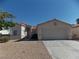 Inviting single-story home with a tile roof, arched entryway, two-car garage, and desert landscaping at 319 Mulberry Glen Dr, North Las Vegas, NV 89031