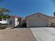 Inviting single-story home with a tile roof, arched entryway, two-car garage, and desert landscaping at 319 Mulberry Glen Dr, North Las Vegas, NV 89031
